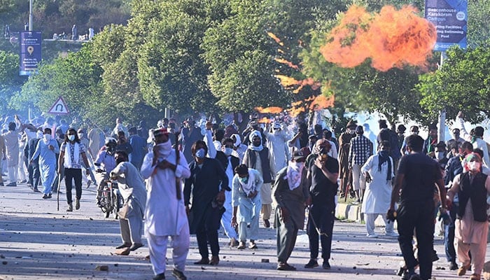 Pakistan Tehreek-e-Insaf (PTI) activists and supporters of former prime minister Imran Khan clash with police during a protest outside the police headquarters where Khan is in custody, in Islamabad on May 10, 2023. —AFP