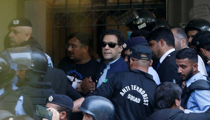 Security officers escort former prime minister Imran Khan, as he appeared in Islamabad High Court on May 12, 2023. — Reuters