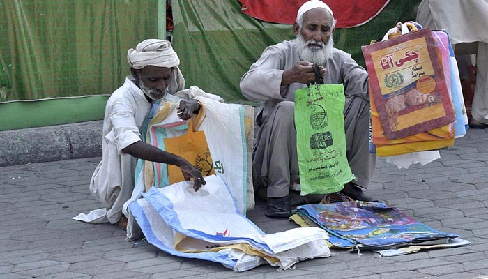 Two elderly vendors waiting for customers to sell shopping bags at Sunday Bazaar in Islamabad on May 14, 2023. — APP