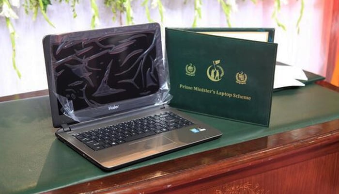 An undated photo of a laptop next to a card announcing the laptop scheme. — APP/File