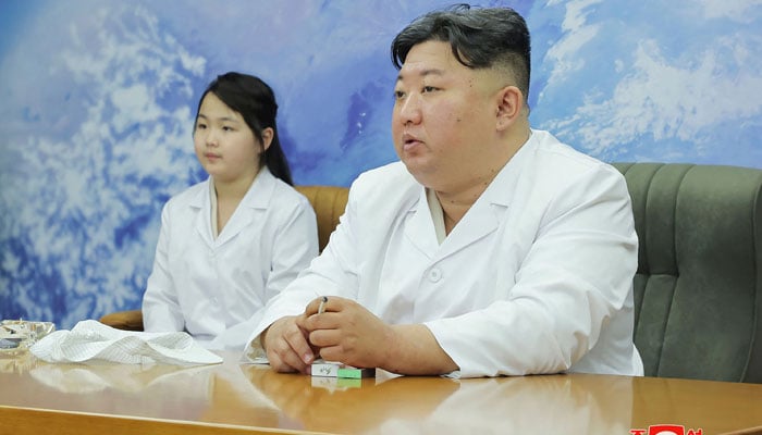 This picture shows North Korean leader Kim Jong Un (R) and his daughter, presumed to be named Ju Ae, meeting with the Non-permanent Satellite Launch Preparatory Committee. — AFP/File