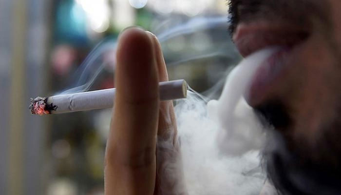 A man smokes outside a tobacco shop in the Saudi capital Riyadh late on June 11, 2017. — AFP/File