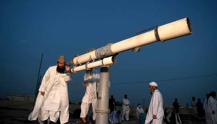 Central Ruet-i-Hilal Committee Chairman Abdul Khabeer Azad uses a telescope to sight the moon in this undated file photo. —APP