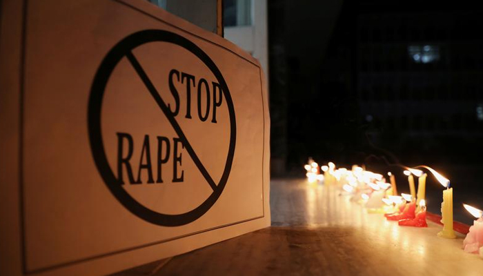 A poster is seen at a candle-lit march. — Reuters