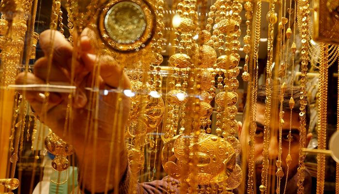 A goldsmith arranges gold ornaments at his shop. — Reuters/File