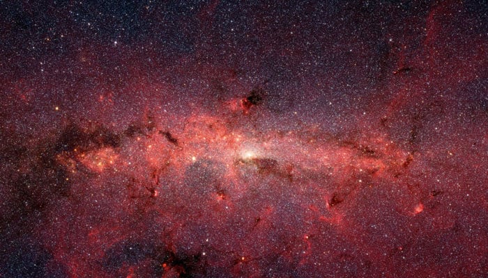 This photo by the Spitzer Space Telescopes infrared cameras penetrates much of the dust, revealing the stars of the crowded galactic centre region. — Nasa/File