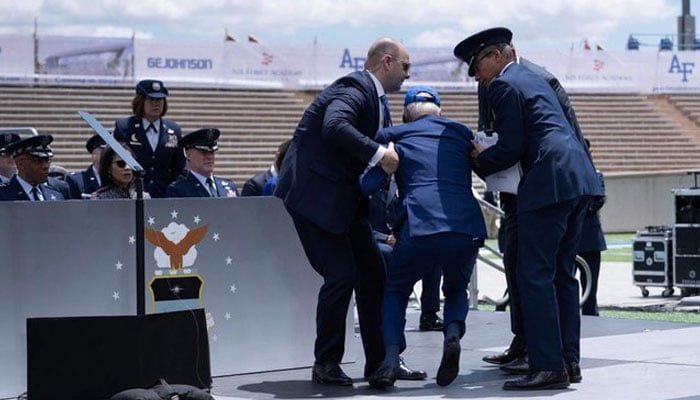 US President Joe Biden is helped up after falling during the graduation ceremony at the United States Air Force Academy, just north of Colorado Springs in El Paso County on June 1, 2023. —AFP