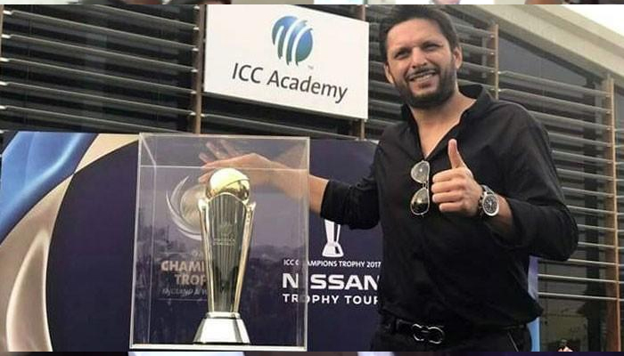 Shahid Afridi poses next to the ICC champions trophy in this undated photograph. — ICC website