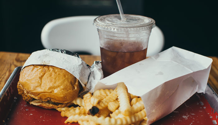 A representational image of a burger, french fries and a drink. — Unsplash/File