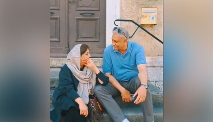 سابق آرمی چیف جنرل (ر) قمر جاوید باجوہ (دائیں) اور ان کی اہلیہ کو ایک ویڈیو سے لی گئی اس میں بات چیت کرتے دیکھا جا سکتا ہے۔  - ٹویٹر