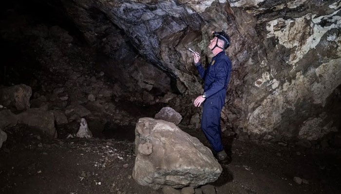 Professor Lee Berger walks inside the Rising Star caves system in The Cradle of Human Kind, in Maropeng, South Africa.—AFP