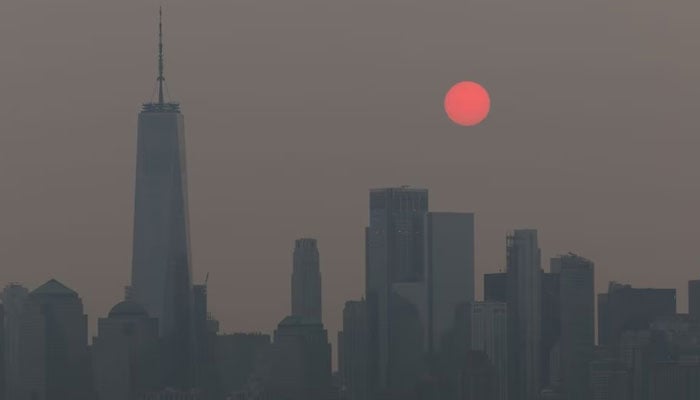 The sun, appearing orange due to smoke and haze from forest fires, rises behind the skyline in New York City, New York, US. — Reuters/File