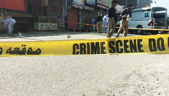 Policemen (right) collect evidence from the crime scene where two cops were shot dead in Mingora, Swat, on June 8, 2023, in this still taken from a video. — Author