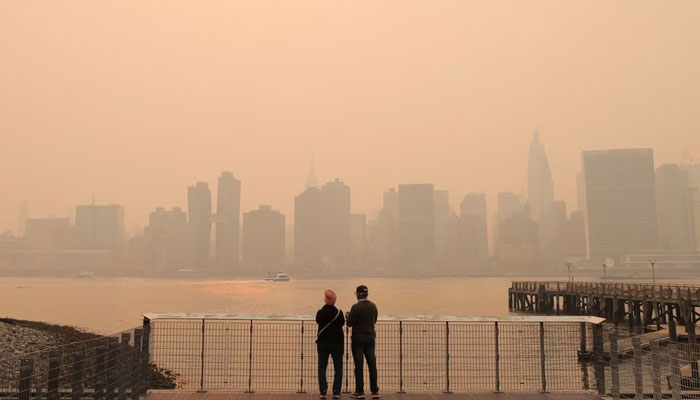 People watch the sunset as haze and smoke caused by wildfires in Canada hang over the Manhattan skyline, in New York City, New York, US, June 7, 2023. — Reuters