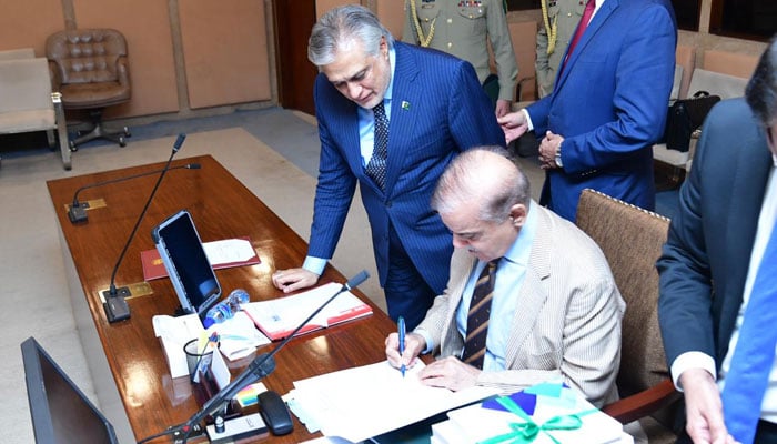 Prime Minister Shehbaz Sharif signs federal budget document for fiscal year 2023-24 on June 9, 2023. — PM Office 
