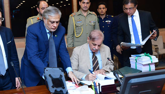 Prime Minister Shehbaz Sharif signing the federal budget documents after the cabinet meeting. — PM Office