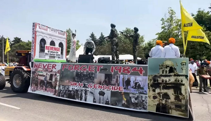 The picture shows a float from the parade featuring Gandhi wearing a blood-stained white saree with her hands up as turban-clad Sikh men pointed guns at her. — Author