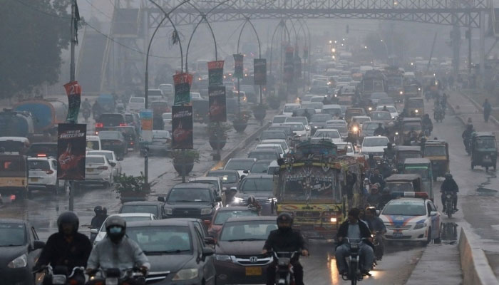 پیر، 27 دسمبر 2021 کو کراچی، پاکستان میں بارش کے دوران گاڑیاں سڑک پر چل رہی ہیں۔ - رائٹرز/فائل