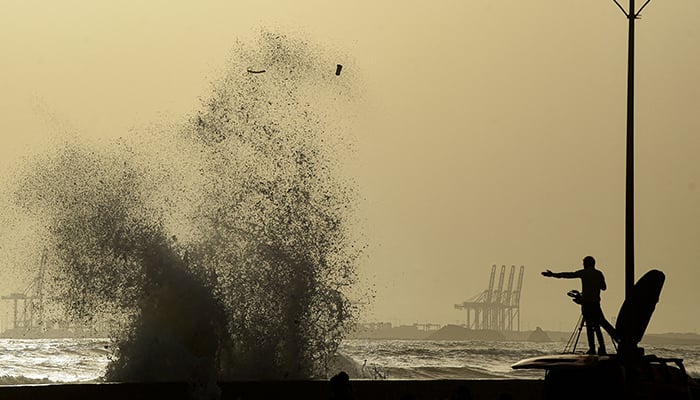 A news cameraman captures high tides at a beach before the due onset of cyclone, in Karachi on June 12, 2023. — AFP
