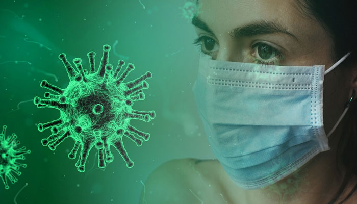 کووڈ وائرس سیل کے ساتھ ماسک پہنے ایک خاتون کی نمائندگی کی تصویر۔  - Pixabay/فائل
