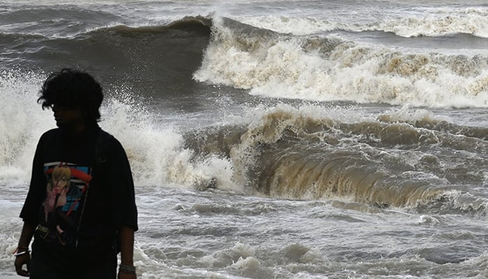 13 جون 2023 کو ممبئی میں ساحل سے اونچی سمندری لہروں کے ٹکرانے کے بعد ایک شخص سمندر کے کنارے سے دور چلا گیا۔ — اے ایف پی