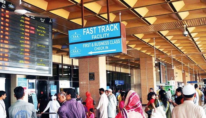 An undate image of people standing at the Jinnah International Airport in Karachi to receive passengers. — AFP/File