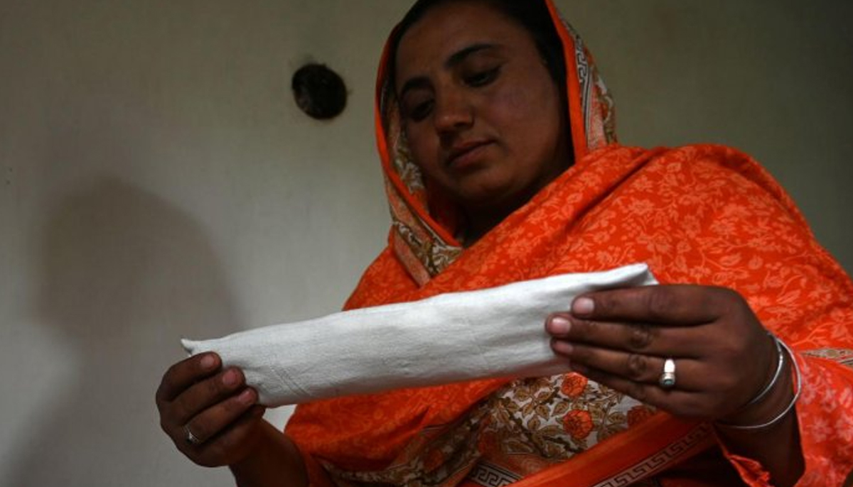 A woman holds a sanitary pad made using a sewing machine at her home in Booni village in Chitral on May 18, 2019. — AFP