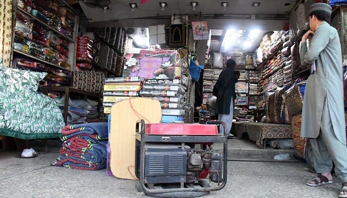 Vendors use generators outside their shops during a major power outage in Karachi on January 23, 2023. — Online
