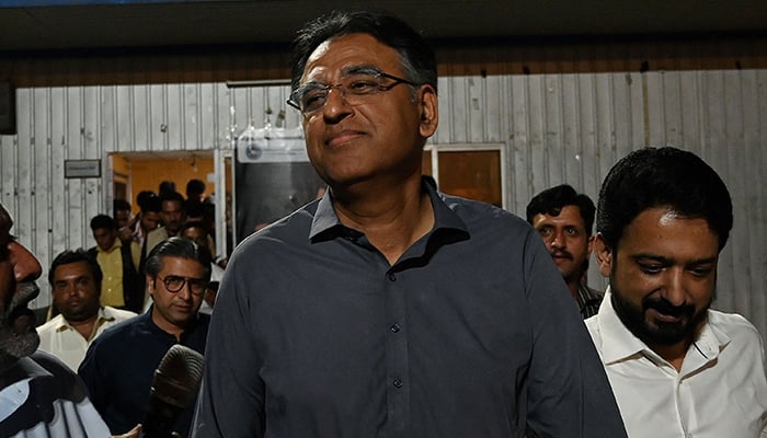 Former finance minister Asad Umar (centre) leaves after announcing to step down from his party position while he was released from prison in Islamabad on May 24, 2023. — AFP