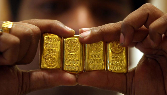 The picture shows a person holding gold biscuits. — Reuters/File