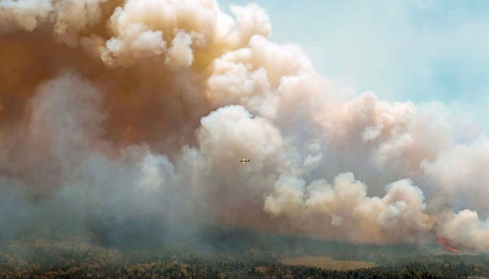 New Brunswick aircraft drops a mix of water and fire retardant as it passes over the wildfire in Barrington Lake, Nova Scotia, Canada in this image released May 31, 2023. — Reuters