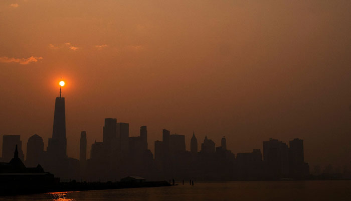 The sun rises behind the One World Trade Center, while the smoke from Canadian wildfires covers the Manhattan borough as it is seen from Liberty State Park on June 8, 2023, in New Jersey. — AFP
