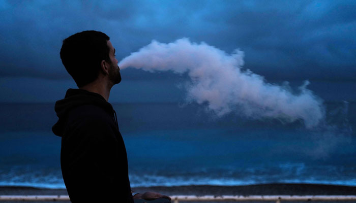 A man smokes an e-cigarette as he walks along the Promenade des anglais on the French Riviera city of Nice. — AFP/File