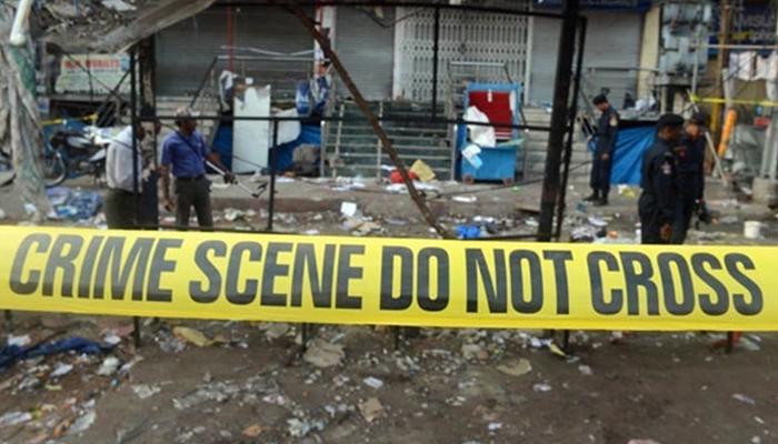 People stand behind a crime scene tape. — Reuters/File