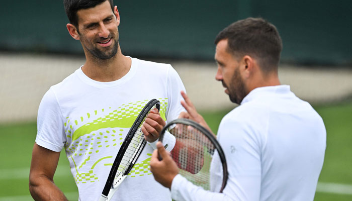Serbia’s Novak Djokovic (left) reacts as he takes part in a training session prior to the start of the 2023 Wimbledon Championships at The All England Tennis Club in Wimbledon, southwest London, on July 2, 2023. — AFP