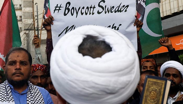 Supporters of Majlis-e-Wahdat-e-Muslimeen carry poster, as they listen to the speech of a leader during a protest, to denounce the desecration of the Quran outside a mosque in the Swedish capital Stockholm, in Karachi, Pakistan July 2, 2023. — Reuters