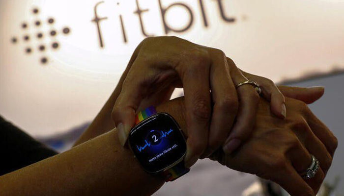 برلن، جرمنی میں 3 ستمبر 2020 کو ایک ملازم IFA کنزیومر ٹکنالوجی میلے میں Fitbit سمارٹ واچ پر الیکٹرو کارڈیوگرام فنکشن استعمال کر رہا ہے