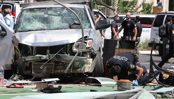 Members of Israeli security and emergency personnel work at the site of a reported car ramming attack in Tel Aviv on July 4, 2023. — AFP