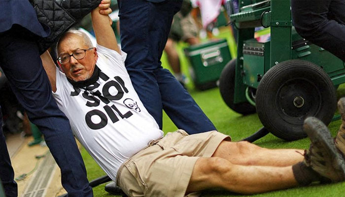 A protester is dragged away after a second disruption to play on Wimbledons court 18.—Reuters