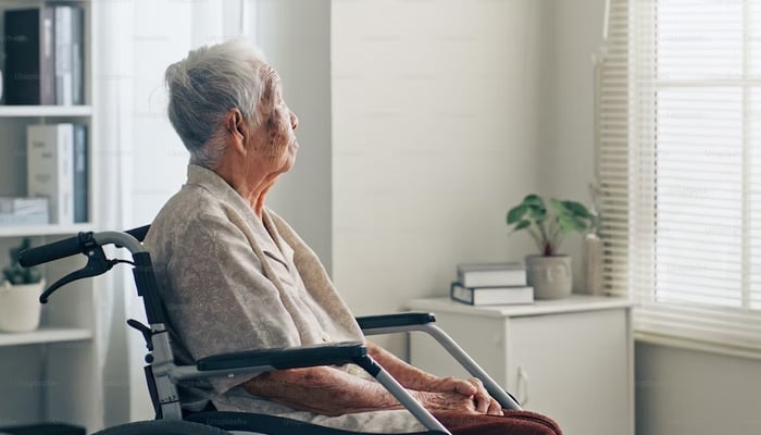 A representational image of an old man can be seen sitting in front of the oldage window. — Unsplash/File