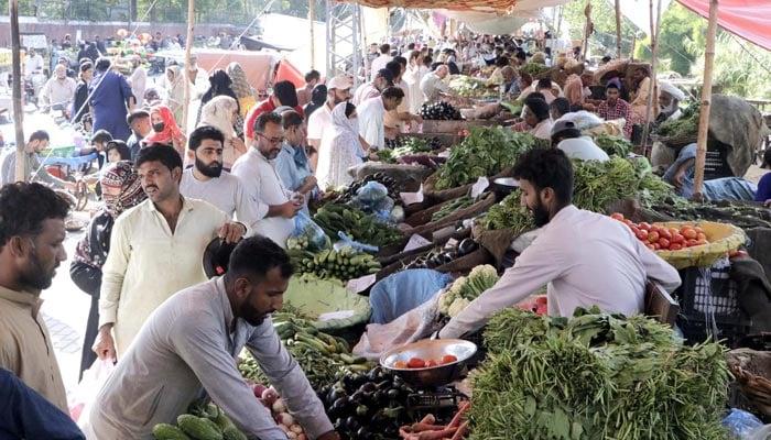People buy vegetables at a stall at a weekly bazar in Shadman area in Lahore on Sunday, October 02, 2022. — PPI/File