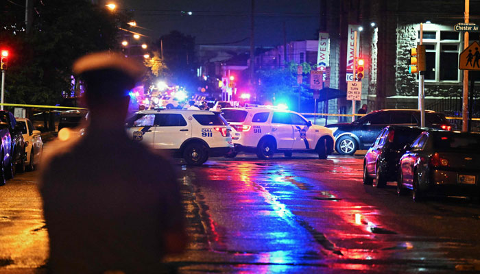 Police vehicles can be seen as authorities work on the crime scene where a shooting took place on July 3, 2023, in Philadelphia. — AFP