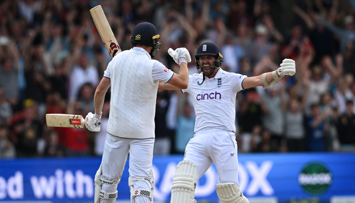 England´s Mark Wood (right) celebrates with England´s Chris Woakes after Woakes hits a boundary to win the test match on day four of the third Ashes cricket Test match between England and Australia at Headingley cricket ground in Leeds, northern England on July 9, 2023. — AFP