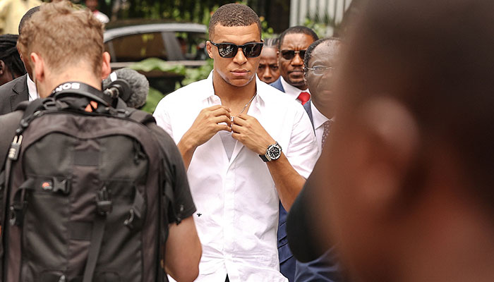 Paris Saint-Germain and France national football team star striker Kylian Mbappe (C) leaves after a meeting with the Prime Minister of Cameroon Joseph Ngute at the Prime Minister´s office in Yaounde on July 7, 2023, during a charity visit and a tour of his father´s village.