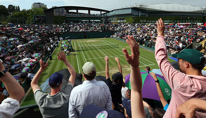 TOPSHOT - Spectators perform the wave during the men´s singles tennis match between Spain´s Alejandro Davidovich Fokina and Denmark´s Holger Rune on the sixth day of the 2023 Wimbledon Championships at The All England Tennis Club in Wimbledon, southwest London, on July 8, 2023.—AFP
