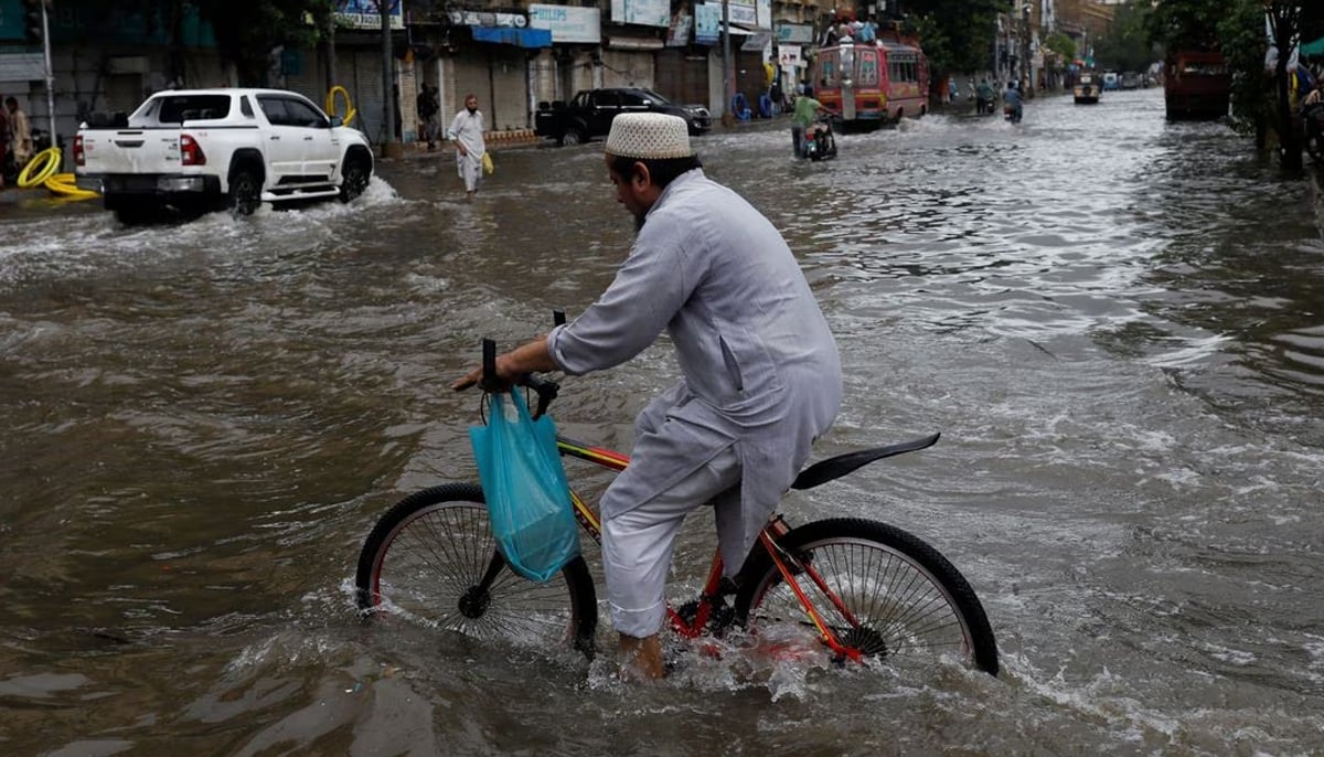 A man rides a bicycle along a flooded road, following heavy rains during the monsoon season in Karachi, Pakistan July 25, 2022. — Reuters