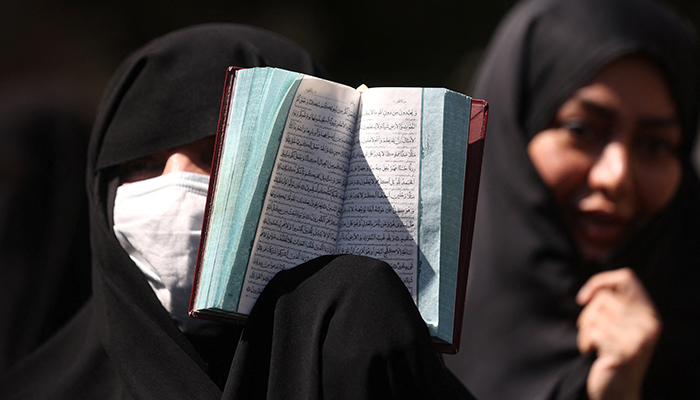 An Iranian protester holds the Quran in her hand during a protest against a man who burned a copy of the Quran outside a mosque in the Swedish capital Stockholm, in front of the Swedish Embassy in Tehran, Iran, June 30, 2023. — Reuters