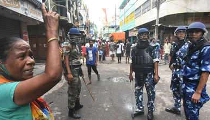 Woman reacts as police stand beside her amid clashes in Indian state of West Bengal. — Times of India