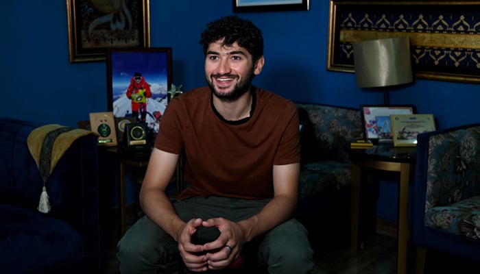 This photo taken on June 27, 2023 shows mountaineer Shehroz Kashif speaking during an interview with AFP inside his home in Lahore.