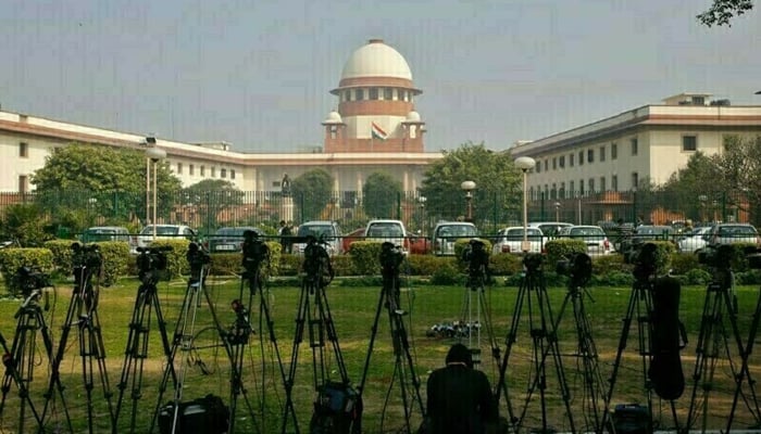 A television journalist sets his camera inside the premises of the Supreme Court in New Delhi. — Reuters/File